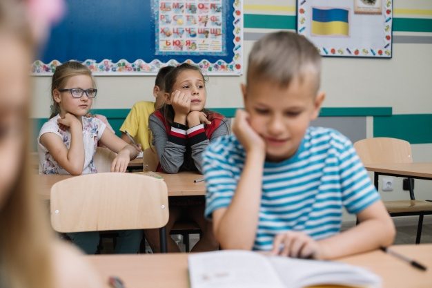 boy-sitting-leaning-hand-reading_23-2147664187